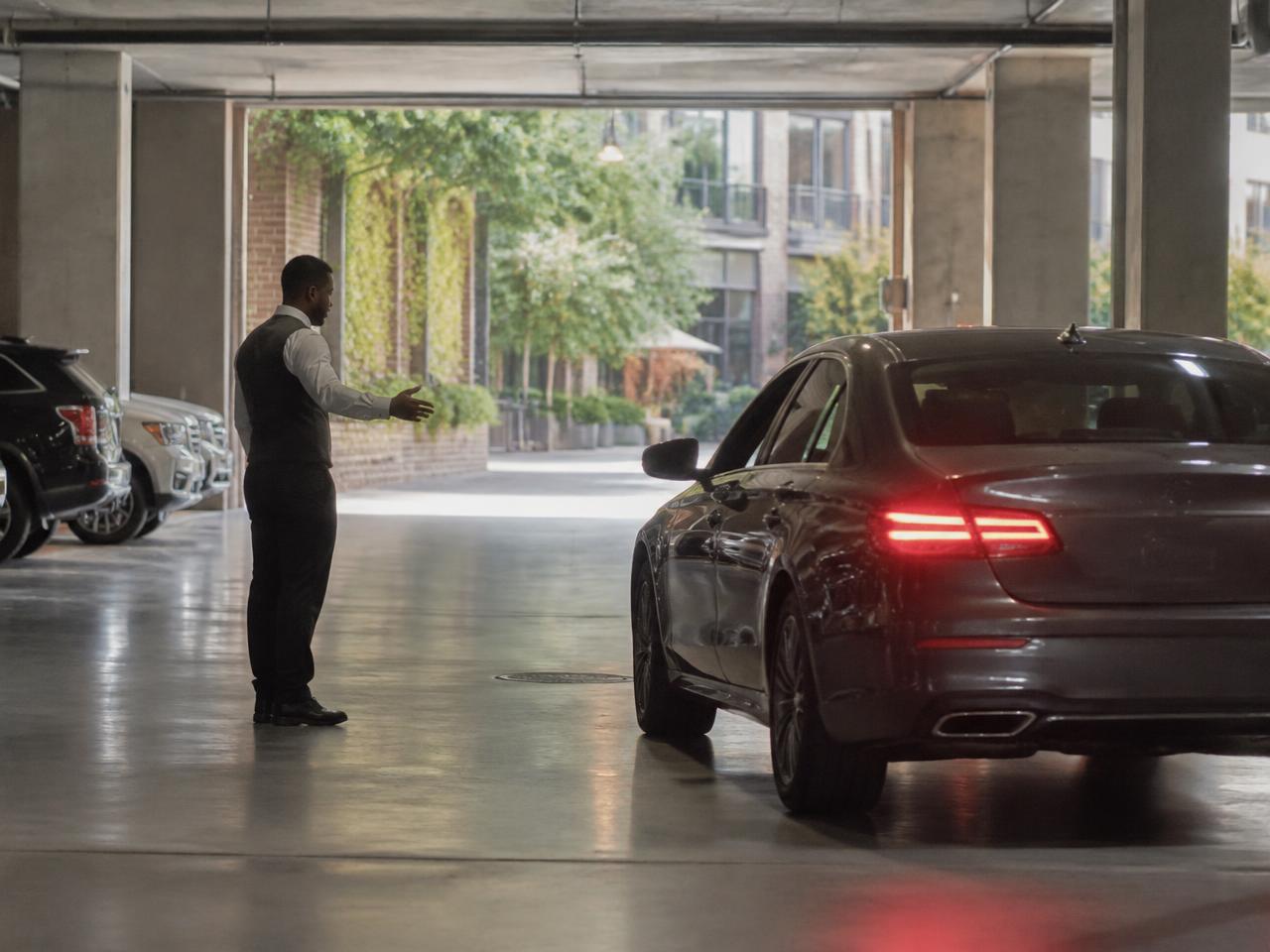 A gloved attendant carefully placing a vehicle key on a valet podium
